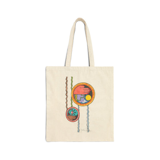 An off-white canvas tote bag with two shoulder straps, featuring a colorful abstract geometric print of hanging circular ornaments on the front.  Also available in Black.